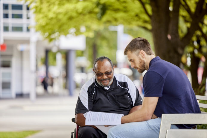 Participant and worker in the park talking about culturally safe and appropriate support capabilities in the Framework